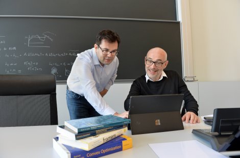 two researchers look at laptop